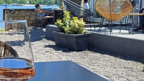 Un espacio al aire libre con un árbol grande, una mesa de vidrio y sillas.