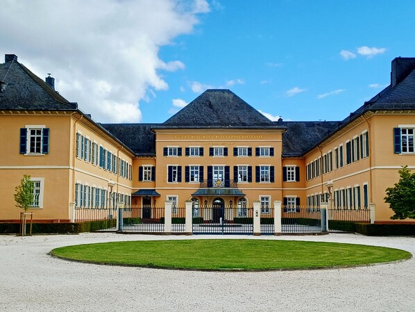 Un grand bâtiment symétrique, doté d’une cour intérieure, de nombreuses fenêtres et d’une entrée imposante.