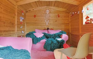 A cozy cabin interior with a bed, a chair, and a window with decorations. - Luxury holiday home with private sauna in Lunteren (Lunteren)