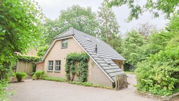 A house with a sloped roof, brick walls, and a small front porch.