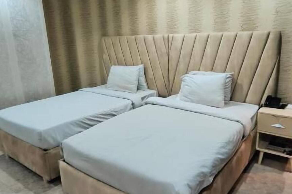 Ein Doppelbett mit Kopfteil, Nachttisch und Beistelltisch.