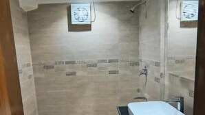 A bathroom with a toilet, a sink, and a shower. - Sea Shell Palace (Dhaka)