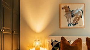 A bedroom with a bed, a nightstand with a lamp, a framed artwork, and a wardrobe. - Beautiful One Bedroom Apartment | Town Centre (North Yorkshire)