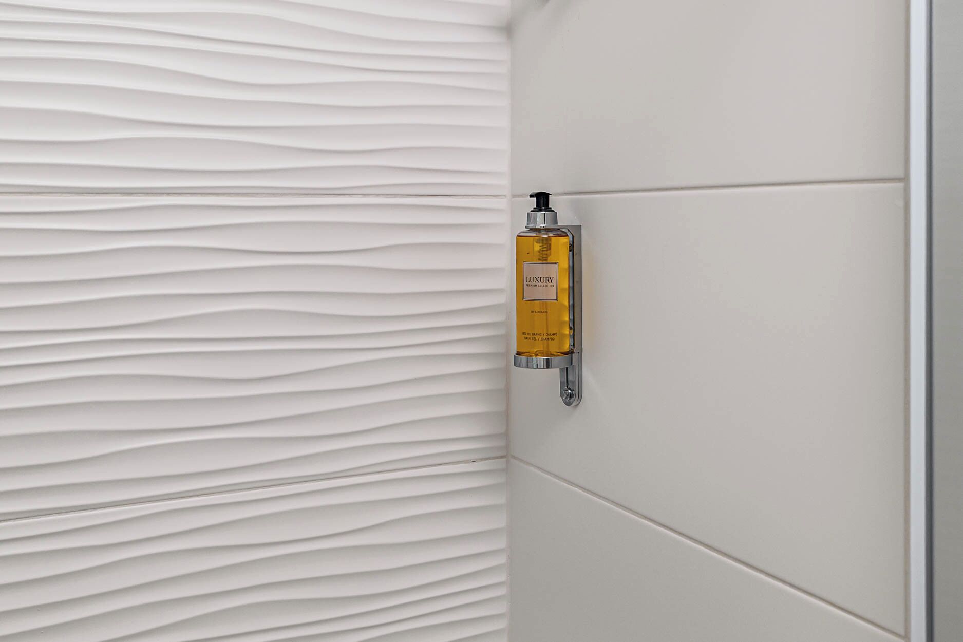 Ein Badezimmer mit strukturierter Wand und einer Wandmontage mit luxuriösem Shampoo.