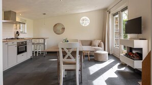 Eine moderne Küche mit Essbereich, einer Couch und einem Fernseher.