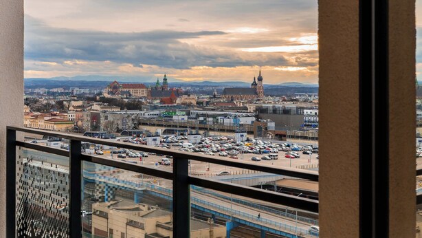 Kaupunkikuva, jossa näkyy rakennuksia, parkkipaikka ja silta.