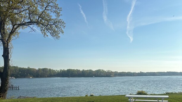 A picnic table by a lake with a clear sky and distant trees. - Waterfront Studio minutes from Downtown Annapolis and Naval Academy (Edgewater)