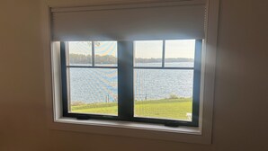 A window with a view of a body of water and a grassy area. - Waterfront Studio minutes from Downtown Annapolis and Naval Academy (Edgewater)