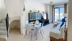 Un espace de vie moderne comprenant un coin repas, un canapé et un escalier.