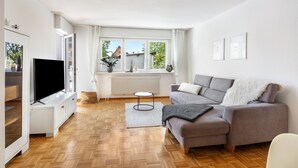 Ein modernes Wohnzimmer mit einer Couch, einem Fernseher und einer Heizung.