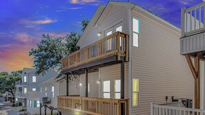 A two-story mobile home with a balcony, a satellite dish, and a small deck. - 7 Bedrooms-OceanLakes-Sleeps18-GolfCart Included (Myrtle Beach)
