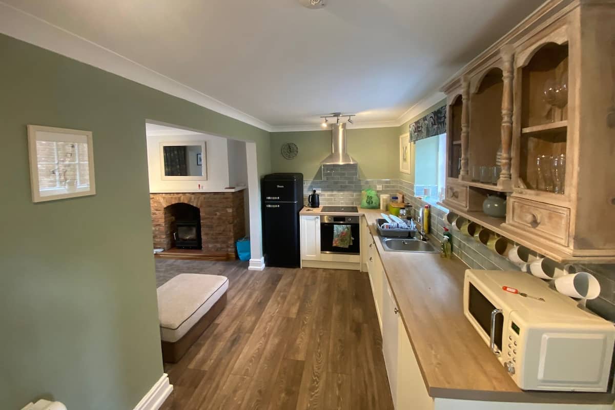 A compact kitchen with a built-in oven, microwave, and a small dining area.