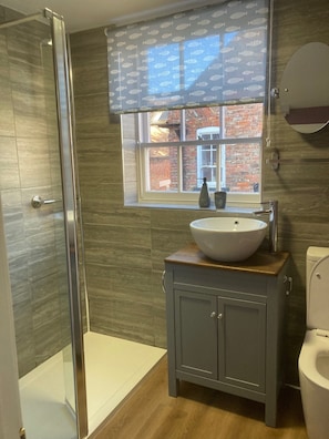 A bathroom with a shower, a sink, and a toilet. - Ribston Cottages (Barrow upon Humber)