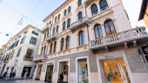 A historic building with multiple storefronts, including a visible entrance to a restaurant. - Historic and elegant Catullo residence (Verona)