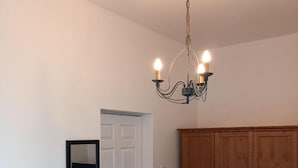 Une pièce avec une porte blanche, une armoire en bois et un lustre.