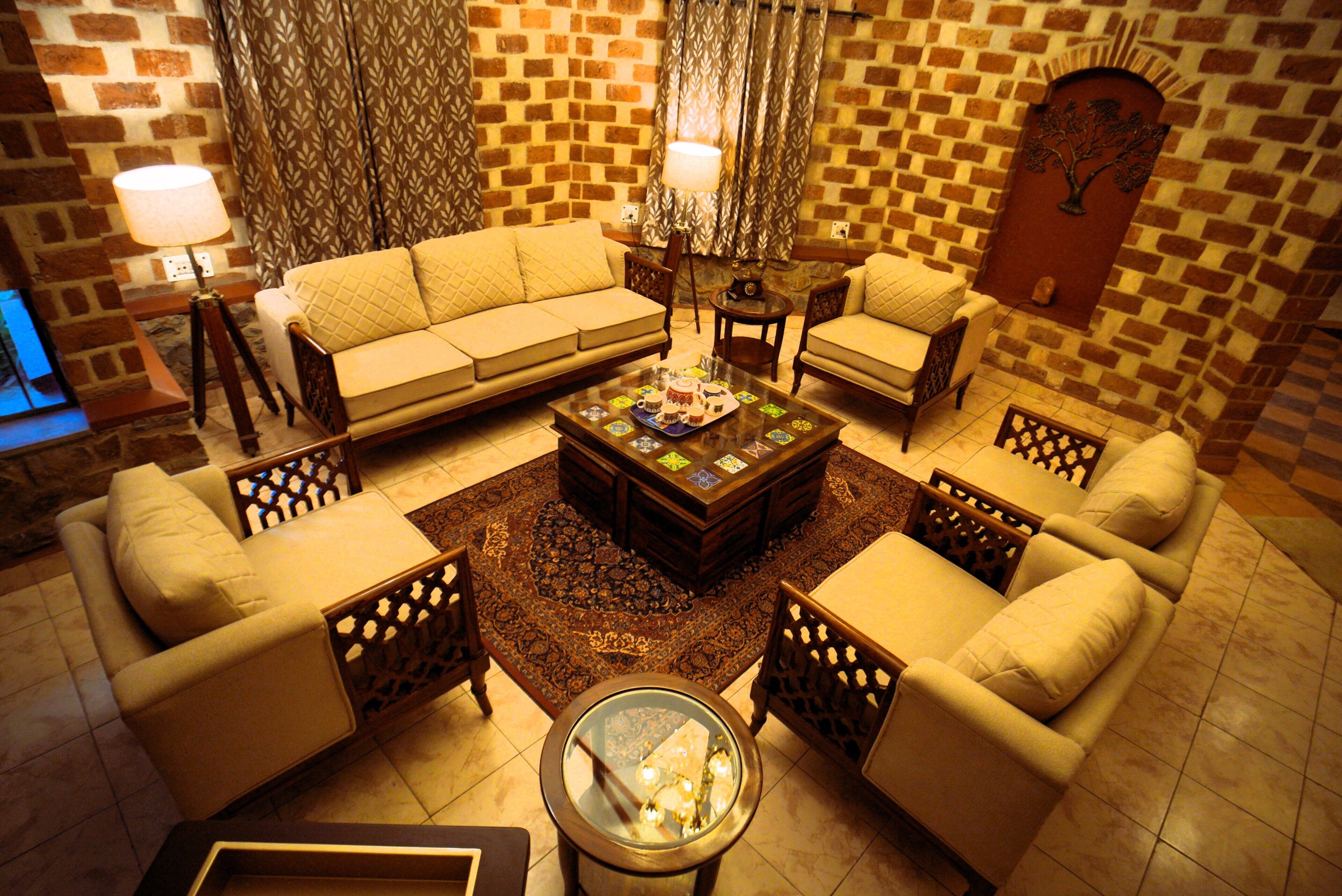 A living room with a sofa set, a coffee table, and a patterned rug.
