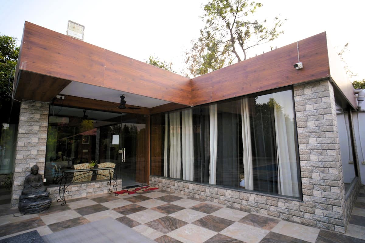 Un edificio moderno con fachada de piedra, ventanas grandes y suelo a cuadros.