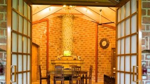 A traditional Japanese-style room with tatami mats, a low table, and sliding doors. - The Mannat Farms (Taoru)