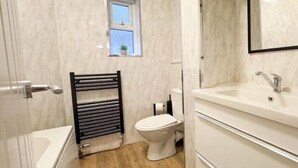Kylpyhuone, jossa on wc, pesuallas ja pyyheteline.