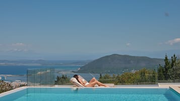 Una piscina al aire libre de temporada, sombrillas