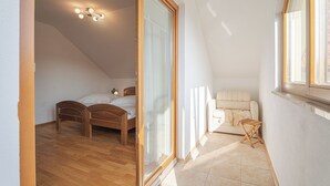 Une chambre à coucher avec un lit en bois, un canapé, une petite table et une fenêtre donnant sur un beau paysage.