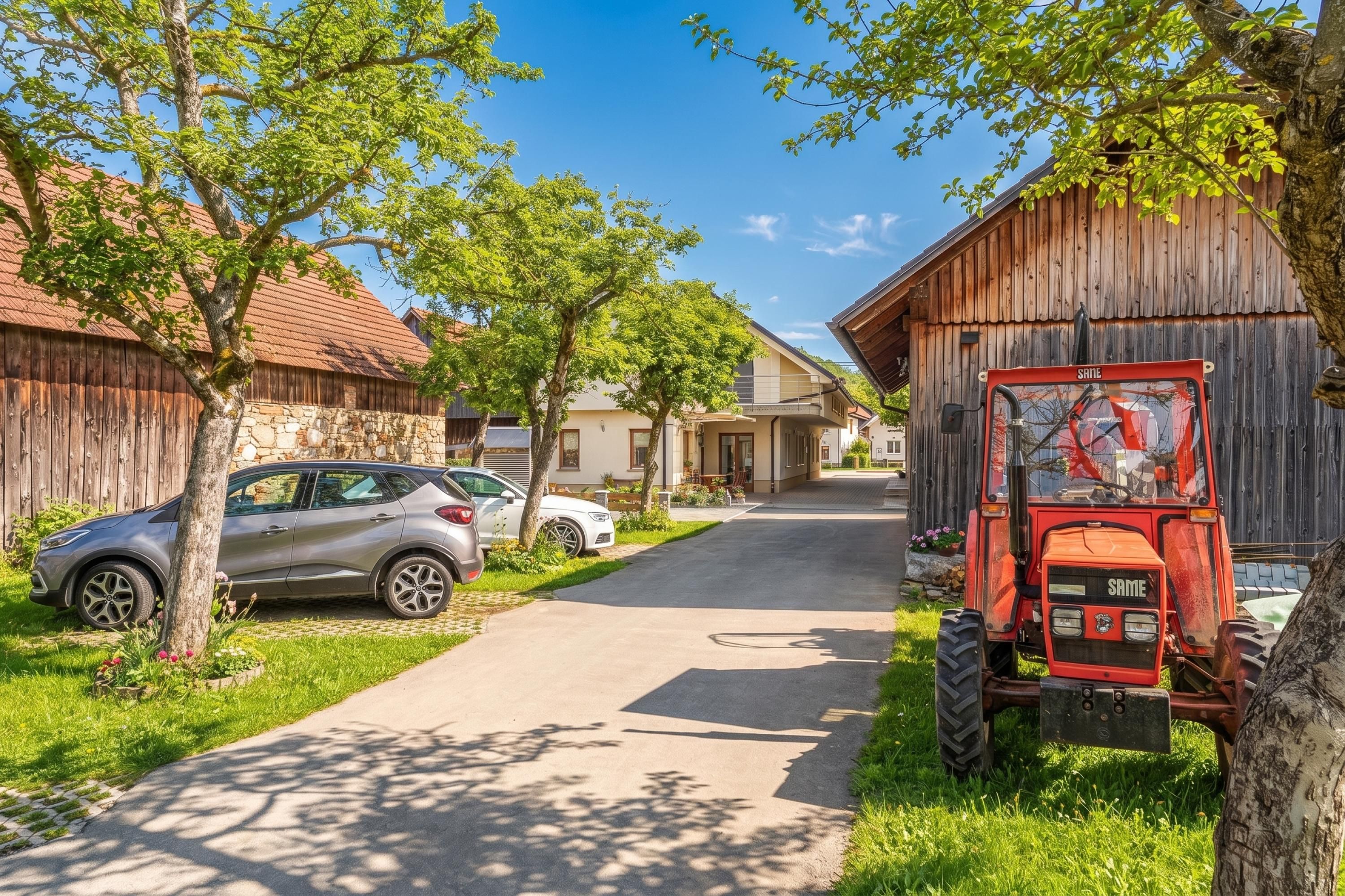 A rural street with a parked car and a red tractor.