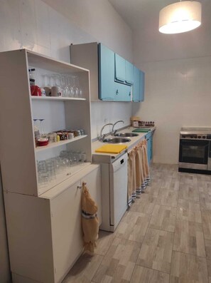 A kitchen with white cabinets, a sink, a stove, and a hanging towel. - Villa near the beach with garden, private parking for families,groups & climbers (san vito lo capo)