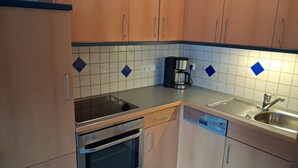 Keittiössä on liesi, uuni, astianpesukone, kahvinkeitin ja pesuallas.