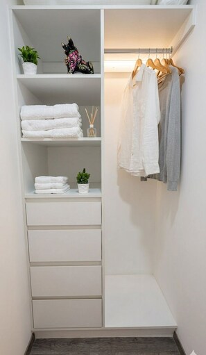 Un armario vestidor con repisas, una barra para colgar ropa y cajones.