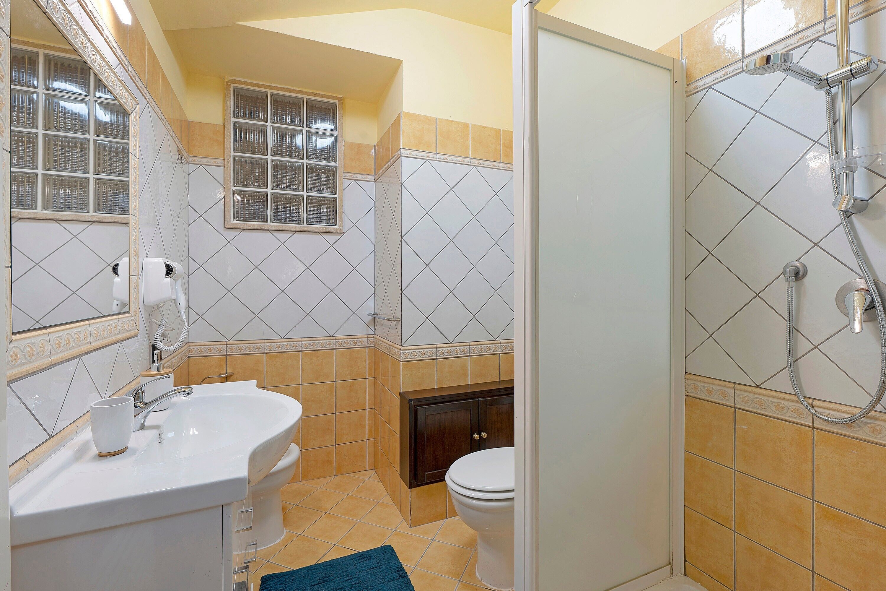 A bathroom with a sink, toilet, and shower.