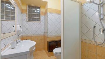 A bathroom with a sink, toilet, and shower.