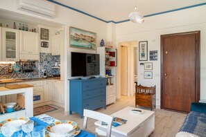 Un espace de vie compact comprenant une cuisine, un coin repas et une chambre.