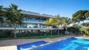 A modern hotel with a swimming pool, palm trees, and a well-maintained garden. - Beachfront Premium Terraza piscina Javea (Javea)