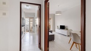 A modern interior with a dining area, kitchen, and living space. - Apt. S. Lourenço Beachfront – No Sea View, Shared Pool, Balcony & Wi-Fi (Armação de Pêra)