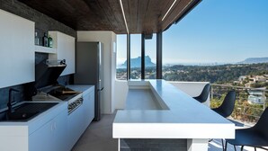 Ett modernt kök med utsikt över en stadsbild och berg.