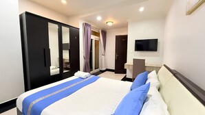 Une chambre d’hôtel comprenant un lit, une armoire, une télévision et une porte donnant sur une autre pièce.