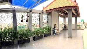 Un espace piscine sur le toit, doté d’un coin salon abrité, de plantes en pot et offrant une vue sur le paysage environnant.