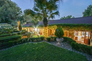 A well-maintained garden with a pathway leading to a building with a tiled roof. - The Tuscan Garden Guesthouse (Newcastle)