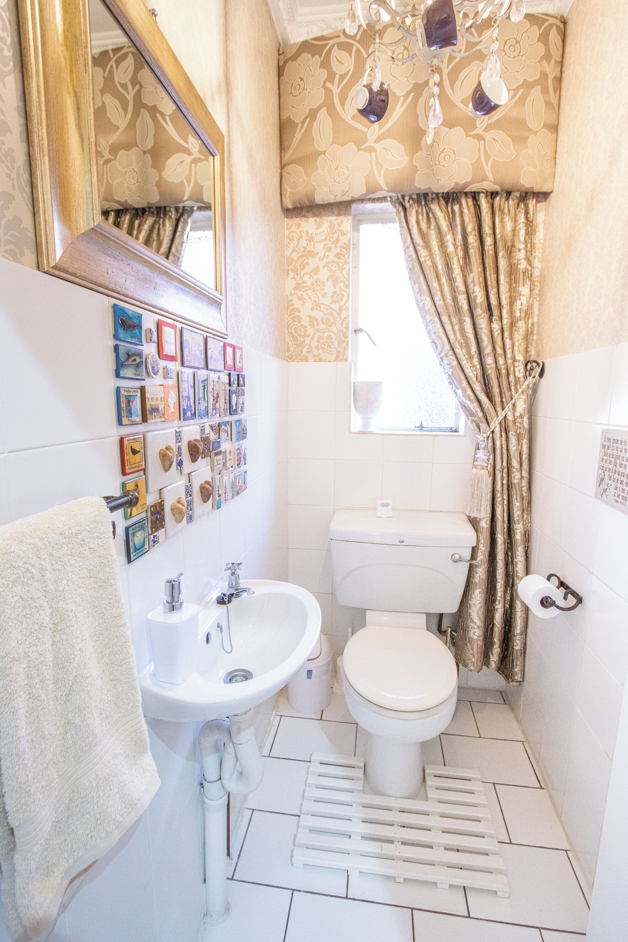 A bathroom with a toilet, sink, and mirror.