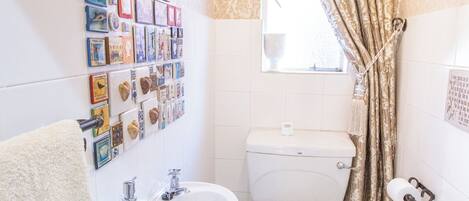 A bathroom with a toilet, sink, and mirror.