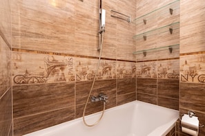 A bathroom with a bathtub, shower, and wall tiles depicting Paris and NYC landmarks. - Bright Apartment with Balcony | Close to Old Town (Gdańsk)