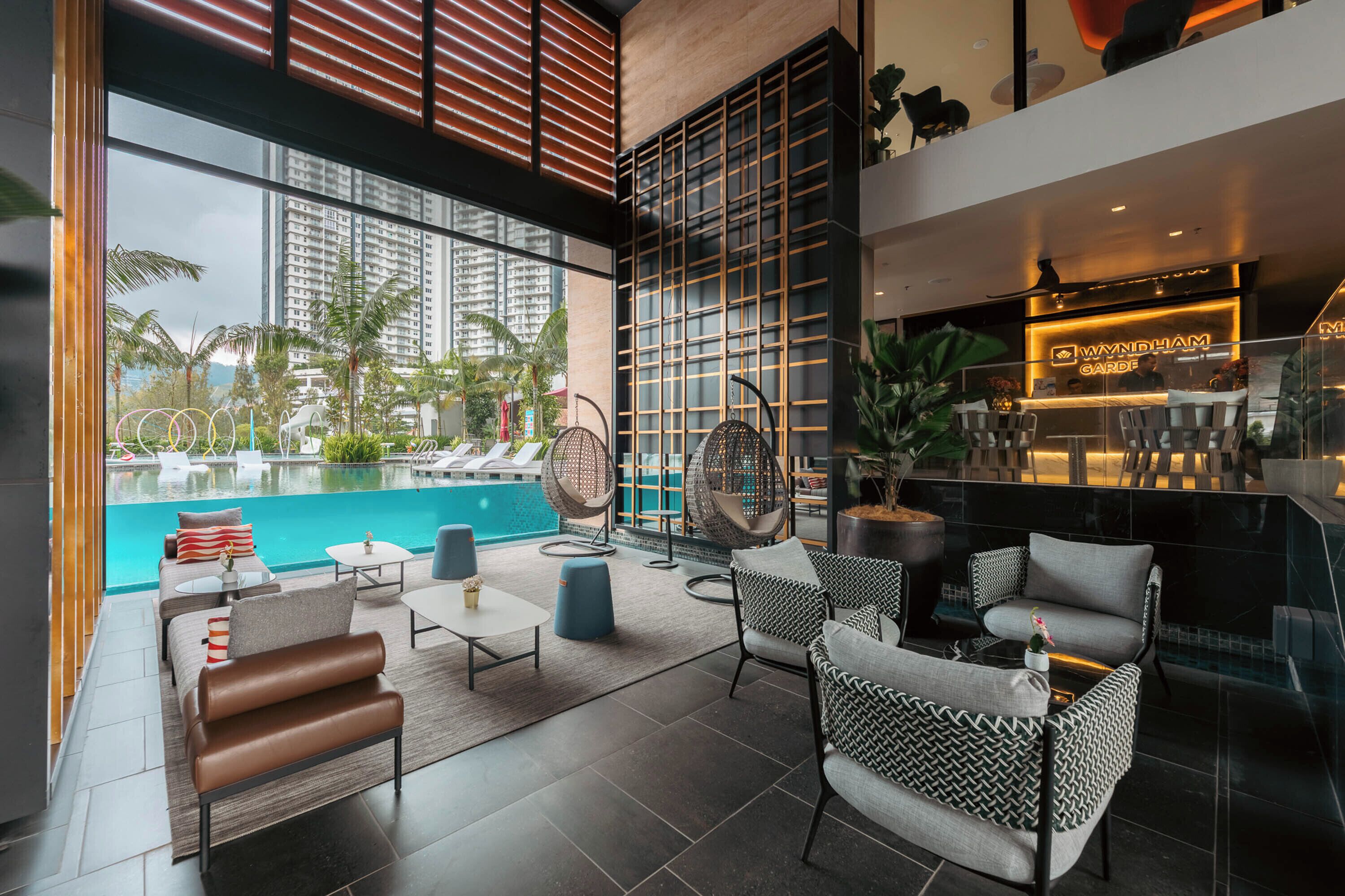 Uma área de estar moderna com vista para a piscina, com assentos confortáveis e um bar.