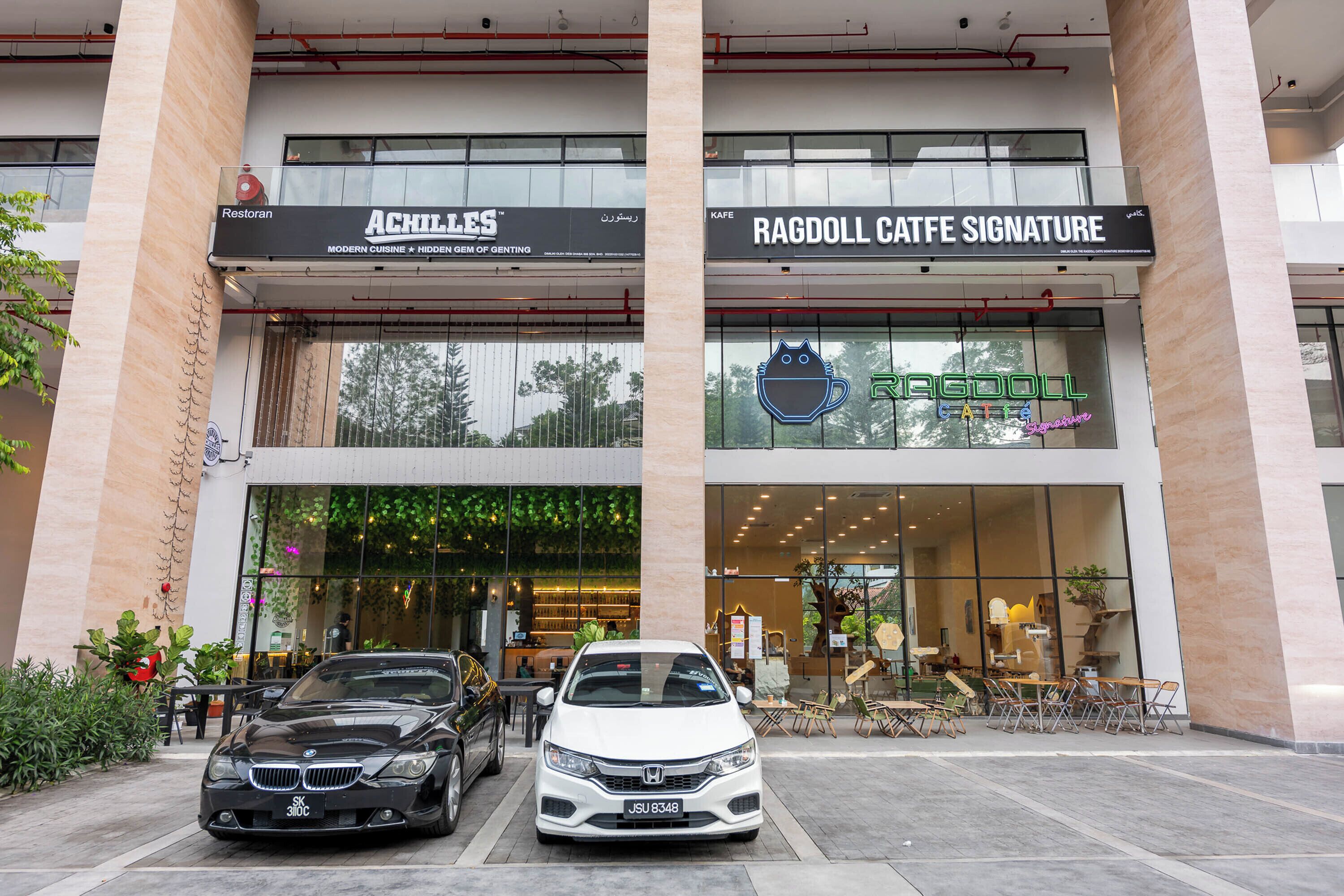 Um edifício com duas vitrines: ACHILES e RAGDOLL CAFFE SIGNATURE.