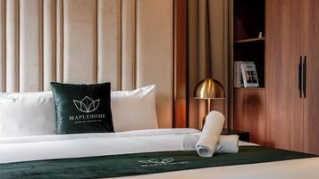 A hotel room with a bed, a pillow with a logo, a lamp, and a wardrobe.