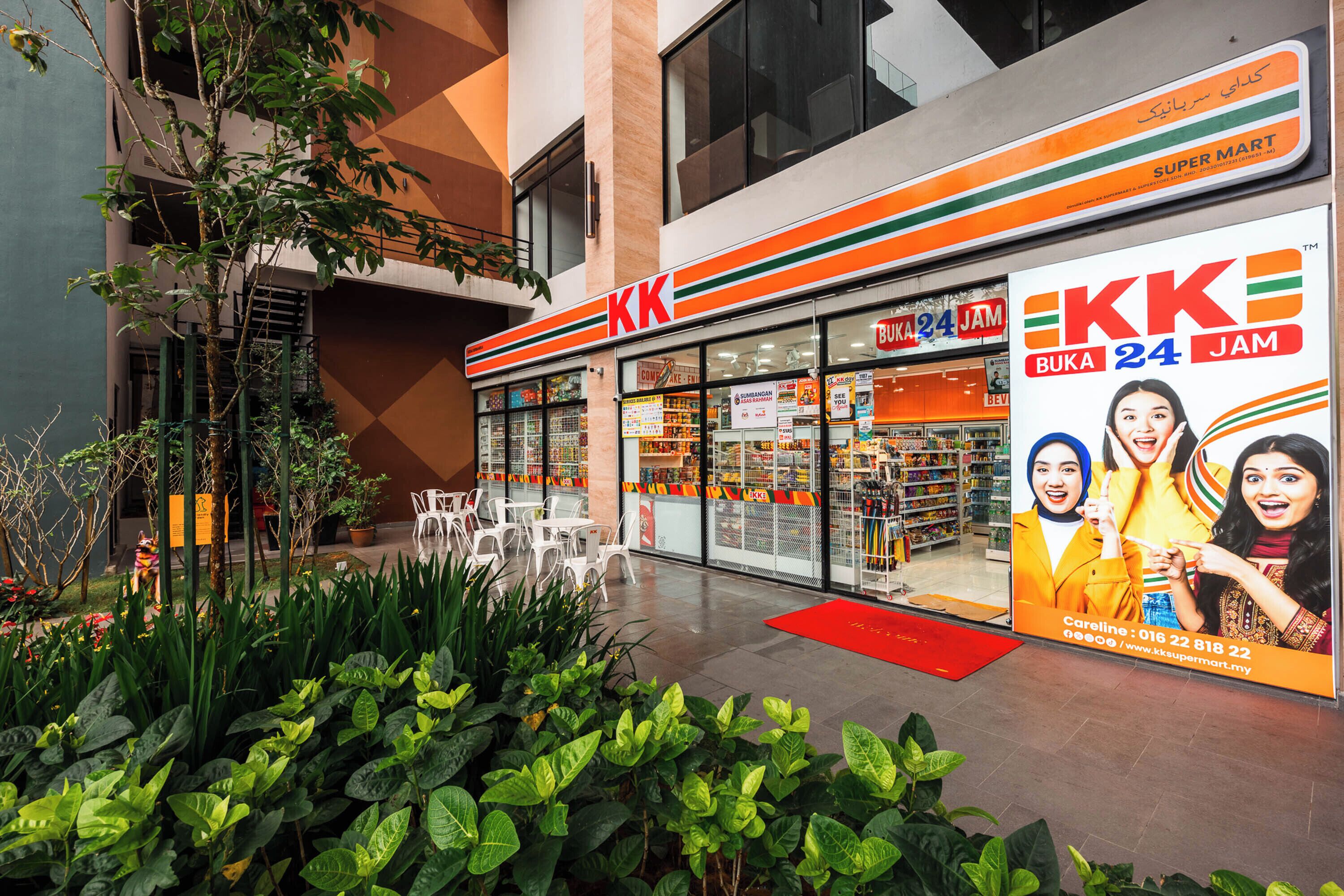 A 24-hour supermarket with a prominent sign, outdoor seating, and a red carpet entrance.