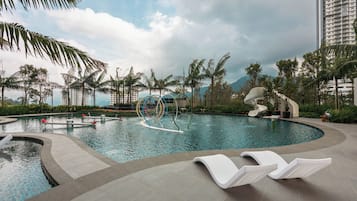 Una piscina al aire libre, sillones reclinables de piscina