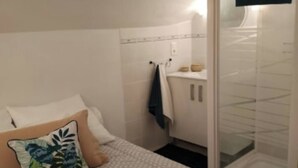 Ett hotellrum med en säng, ett litet badrum och en garderob.