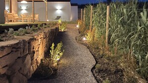 Un chemin menant à un bâtiment doté d’une terrasse et d’un espace couvert.