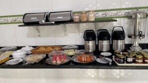 A buffet setup with various food items, condiments, and coffee machines. - Delta Hotel Nova Mutum (Nova Mutum)