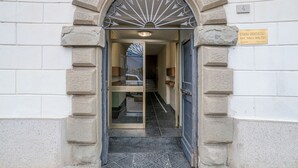 Rakennuksen sisäänkäynti, jossa on kivinen holvikaari, kyltti, jossa lukee ”Studio Dentistico Dott. Galli Walter”, ja laatoitettu lattia.
